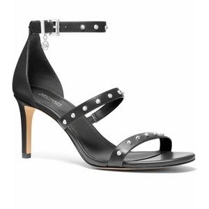 Signature MK logo hardware and polished studs embolden a strappy leather sandal